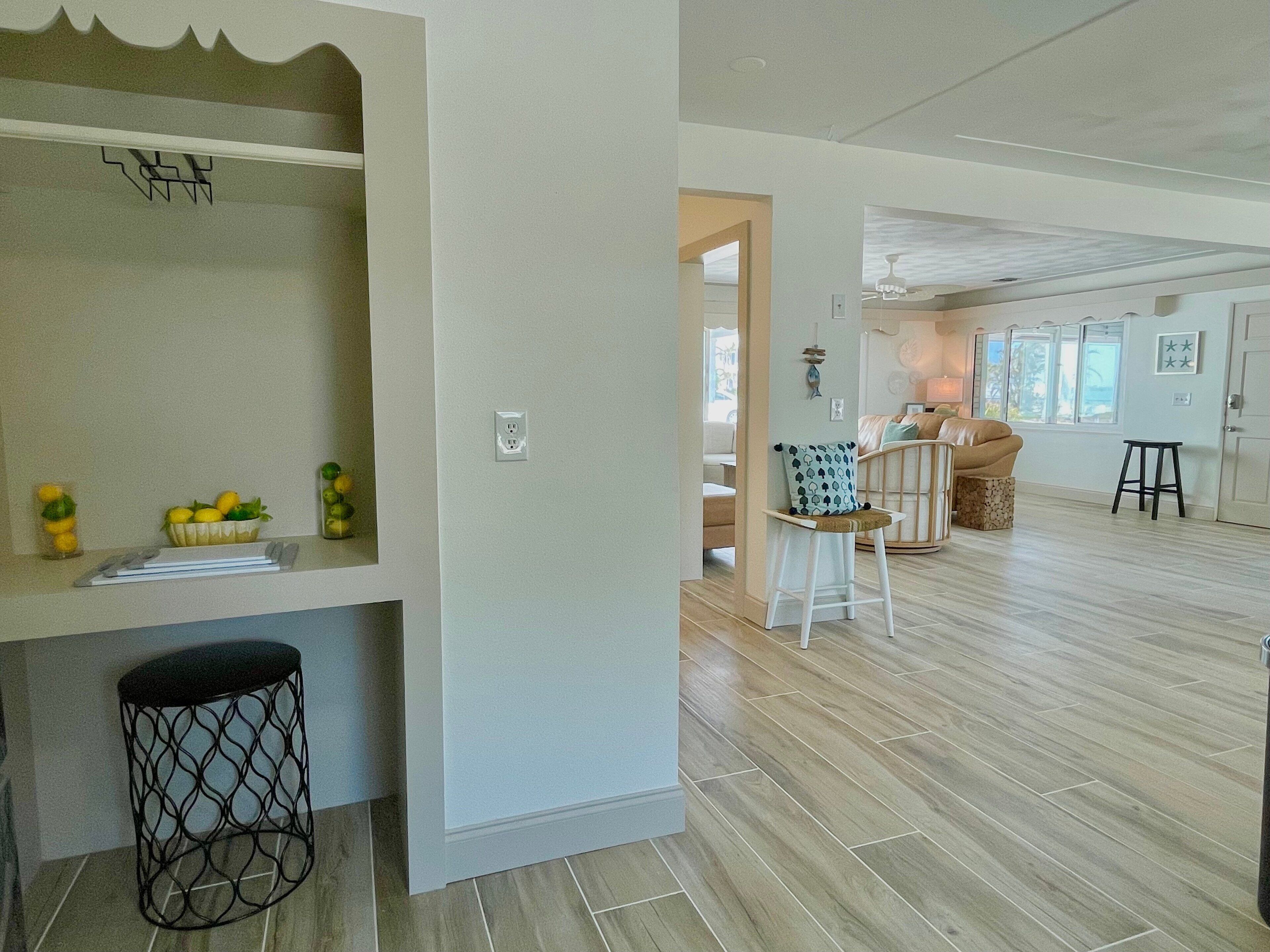 A spacious living area with a kitchen counter, a dining area with a high chair, and a staircase leading to another level.