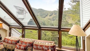 A room with a large skylight, a sofa with patterned cushions, and a lamp.
