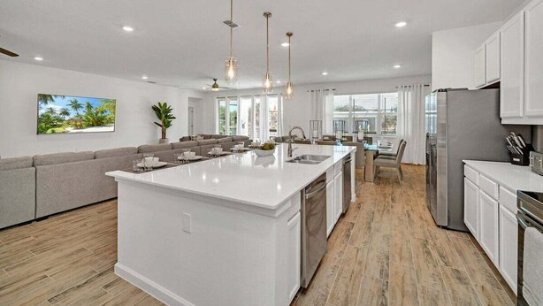 A modern kitchen with a central island, white cabinetry, and pendant lighting. - 2525 Shanti Amazing 15 Suites Mansion (Kissimmee)
