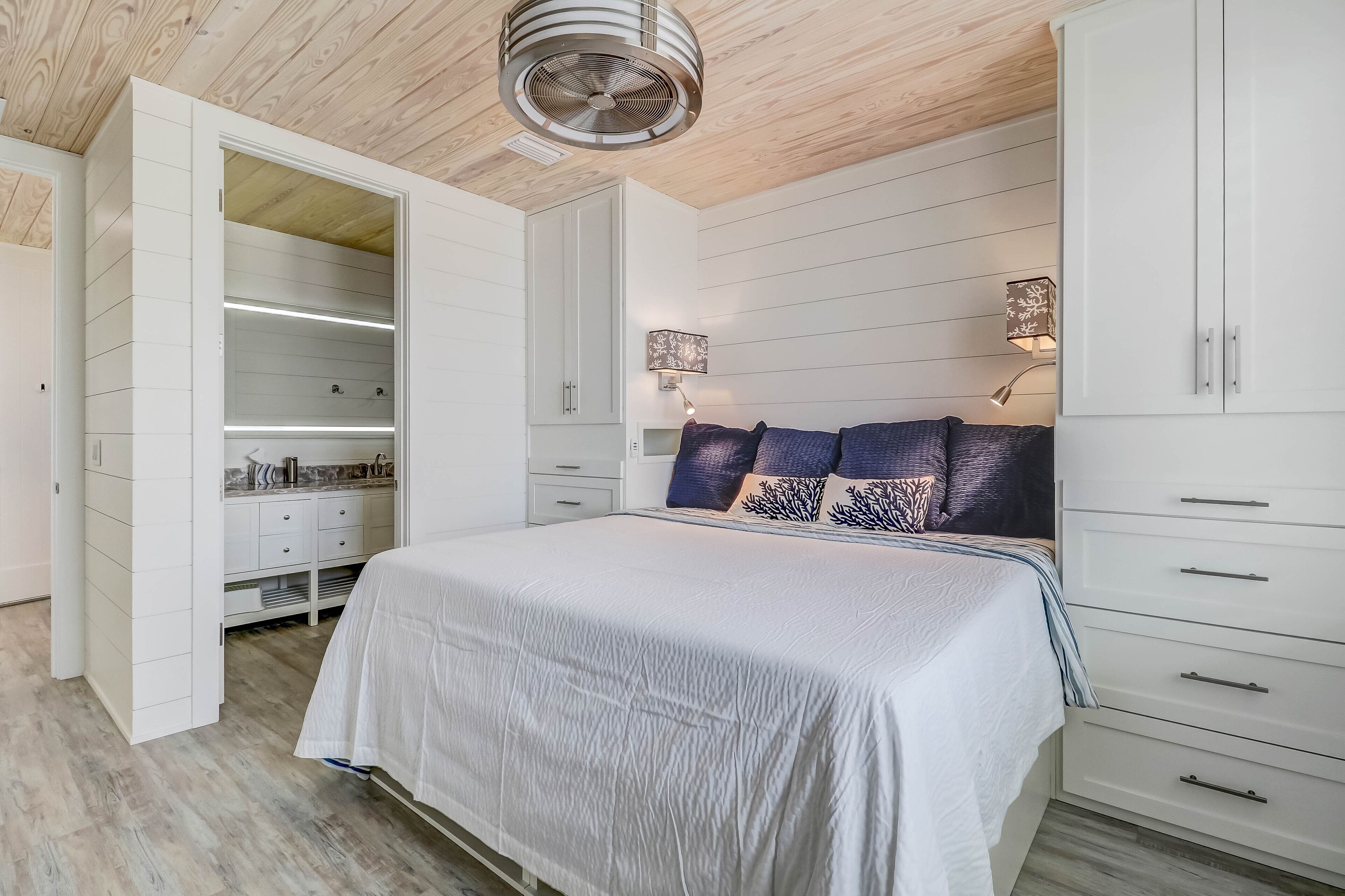 Un dormitorio con cama, armario blanco y vestidor.