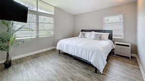 A bedroom with a bed, a nightstand, a potted plant, and a ceiling light. - 3517 River Grove Drive (Tampa)