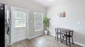 A room with a door, two windows, a potted plant, a table with chairs, and a ceiling light. - 3517 River Grove Drive (Tampa)