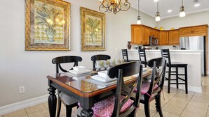 A dining area with a wooden table and chairs, a chandelier, and framed artwork on the wall. - 7407 Excitement DR (Kissimmee)