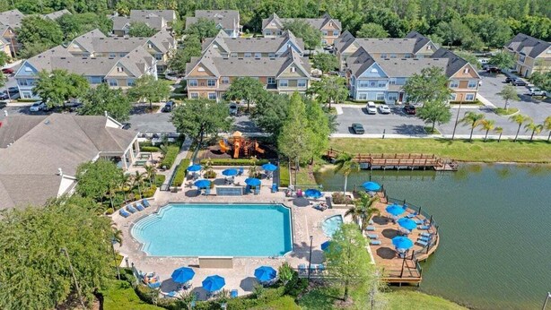 A residential area with a swimming pool, lounge chairs, and a dock over water. - 4005 SAN Sabastian Drive 3bed (Kissimmee)