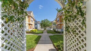 A residential street with houses, a clear sky, and a pathway. - 4005 SAN Sabastian Drive 3bed (Kissimmee)