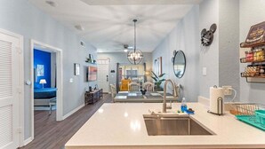 A modern kitchen with a central island, stainless steel sink, and a ceiling fan. - 4005 SAN Sabastian Drive 3bed (Kissimmee)
