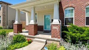 A two-story house with a porch, brick columns, and a blue door. - 3229 Eads Ave (St. Louis)