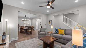 A spacious living room with a sofa, coffee table, and a dining area in the background. - 3323: Uptown Elegant Escape by JZ Vacation Rentals (St. Louis)