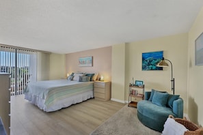 A bedroom with a bed, bedside tables, a nightstand, a sofa, a lamp, and a painting on the wall. - Anchorage Resort 5th Floor 2 Bedroom Condo With Beach Access 0888 (Siesta Key)