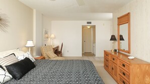 A bedroom with a bed, a dresser, a chair, and a mirror. - Anchorage Resort 9th Floor 2 Bedroom Condo With Balcony Gulf Views Poolbeach 0895 (Siesta Key)