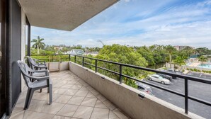 A balcony with a view of a parking area and greenery. - Anchorage Resort 3rd Floor 2 Bedroom Condo South West Balconies 0885 (Siesta Key)