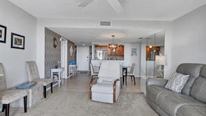 A modern living room with a sofa, armchairs, a dining table, and a kitchen in the background. - Anchorage Resort Siesta Key 6th Floor 2 Bedroom Condo Beach Access 0890 (Siesta Key)