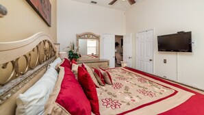 A bedroom with a large bed, a television, a dresser, and a mirror. - Fp8157 - Windsor Palms Resort 4 Bedroom Home With Game Room (Kissimmee)