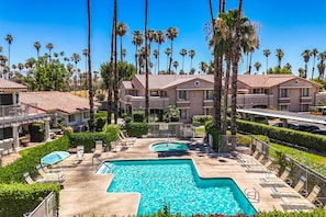 A resort with a swimming pool, lounge chairs, and palm trees. - Farrell N79 (Palm Springs)