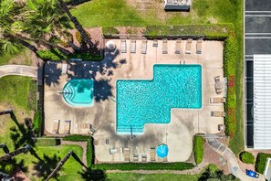 An aerial view of a resort with a large rectangular swimming pool, multiple lounge chairs, and a parking area. - Farrell N79 (Palm Springs)