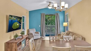 A living room with a dining table, sofa, and TV. - River Oaks 60N (Myrtle Beach)