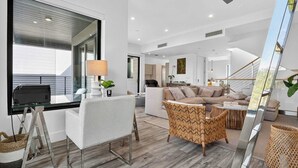 A spacious living area with a modern design, featuring a sofa, a coffee table, and a dining table with chairs. - Shoreline Villa by Rove Rooftop & Beach Access (Hollywood)