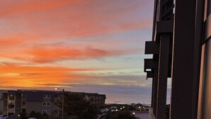 En vy över en bostadsgata under solnedgången, med byggnader och en klar himmel.