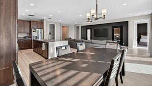Une cuisine moderne avec des meubles en bois foncé, un îlot central et des spots encastrés au plafond.