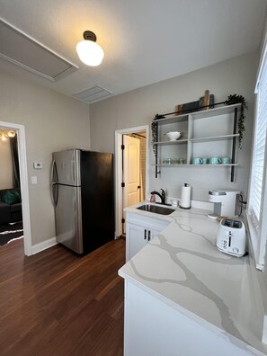 A compact kitchen with a stainless steel refrigerator, a white countertop, a sink, and a toaster. - Updated Condo in Heart of Tampa 1578 (Tampa)