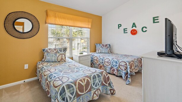 A bedroom with two beds, a ceiling fan, a window with blinds, and a wall with the word "PEACE" spelled out. - Op7678 Windsor Hills 3 Bedroom Private Pool Townhome (Kissimmee)