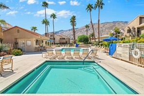 A swimming pool with lounge chairs, palm trees, and a mountainous backdrop. - Plaza Villas 615 (Palm Springs)