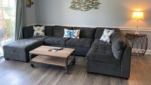 Ein modernes Wohnzimmer mit Ecksofa, Couchtisch und Wanddekoration.