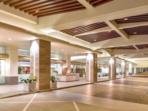 Eine geräumige Lobby mit hohen Decken, großen Säulen und modernem Design.