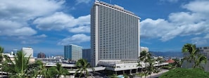 Ein hoch aufragendes Hotel mit modernem Design, das durch eine markante vertikale Struktur und eine flache Dachfläche gekennzeichnet ist.