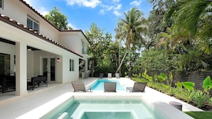 A modern house with a swimming pool, outdoor seating, and lush greenery. - Villa Granada by Rove Waterfront W/pool, Hot Tub (Miami)