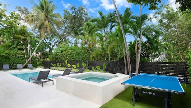 A backyard with two swimming pools, a ping pong table, and lounge chairs. - Villa Granada by Rove Waterfront W/pool, Hot Tub (Miami)