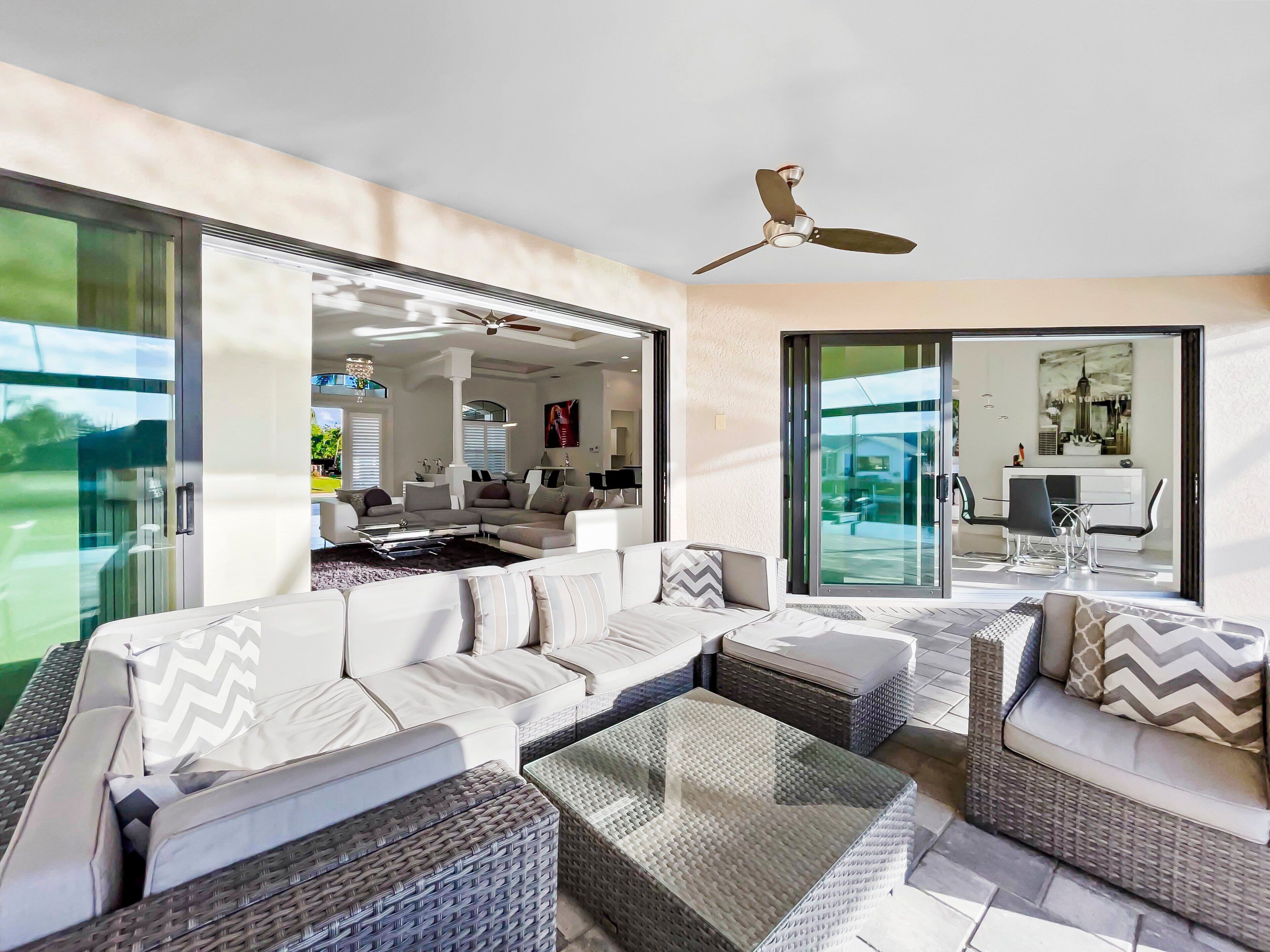 A modern living room with a sectional sofa, a coffee table, and a ceiling fan.
