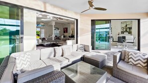 Ein modernes Wohnzimmer mit Ecksofa, Couchtisch und Deckenventilator.