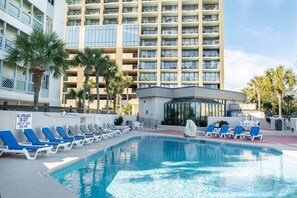 Área de piscina de hotel com espreguiçadeiras e placa de salva-vidas.