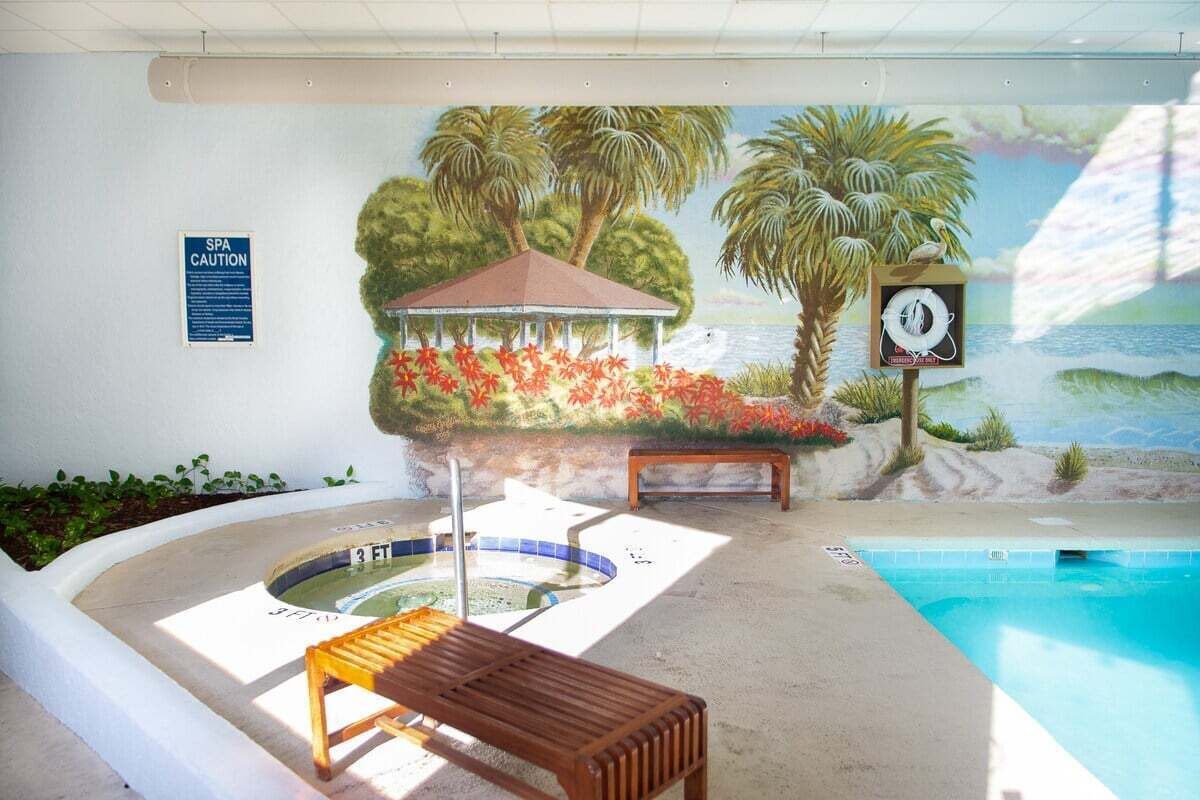 Ett spaområde med en väggmålning, ett bubbelbad och en pool.
