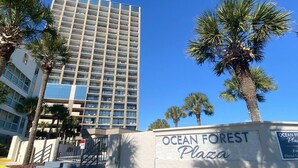 A building with a sign reading "Ocean Forest Plaza" and a palm tree in the foreground. - Ocean Forest 1006 (Myrtle Beach)