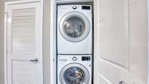 A laundry room with two stacked front-loading washing machines. - Oceanview Paradise at the Beach (Myrtle Beach)