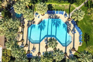 An aerial view of a resort pool area with a large pool, sun loungers, and palm trees. - Deauville 613 (Palm Springs)