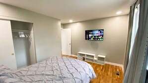 A bedroom with a bed, a TV mounted on the wall, and a closet. - New Listing! The Playhouse With Spa Games & More (Nashville)