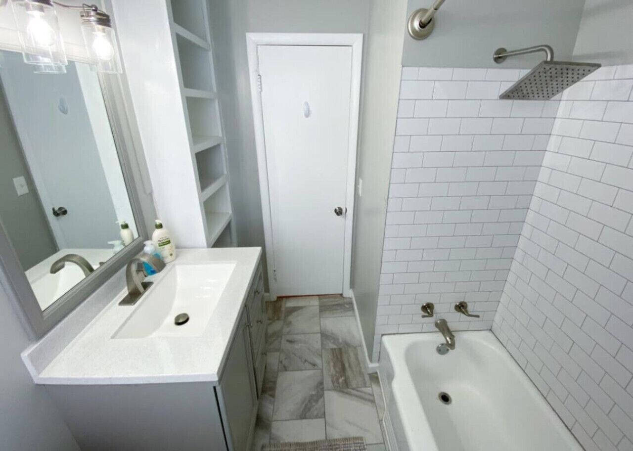 Ein Badezimmer mit Waschbecken, Spiegel und Dusche.