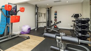 A gym with exercise equipment, a mirror, and a wall-mounted TV. - Beautiful, Pool, Gym, Near Theheights, BBQ (Houston)