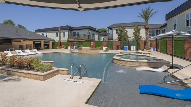 A pool area with lounge chairs, a hot tub, and a covered seating area. - Beautiful, Pool, Gym, Near Theheights, BBQ (Houston)