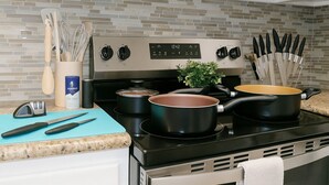 A kitchen with a stove, pots, and utensils. - Beautiful, Pool, Gym, Near Theheights, BBQ (Houston)