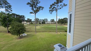 A view of a golf course with a house in the background. - Magnolia Pointe Luster Leaf 4890-303 (Myrtle Beach)