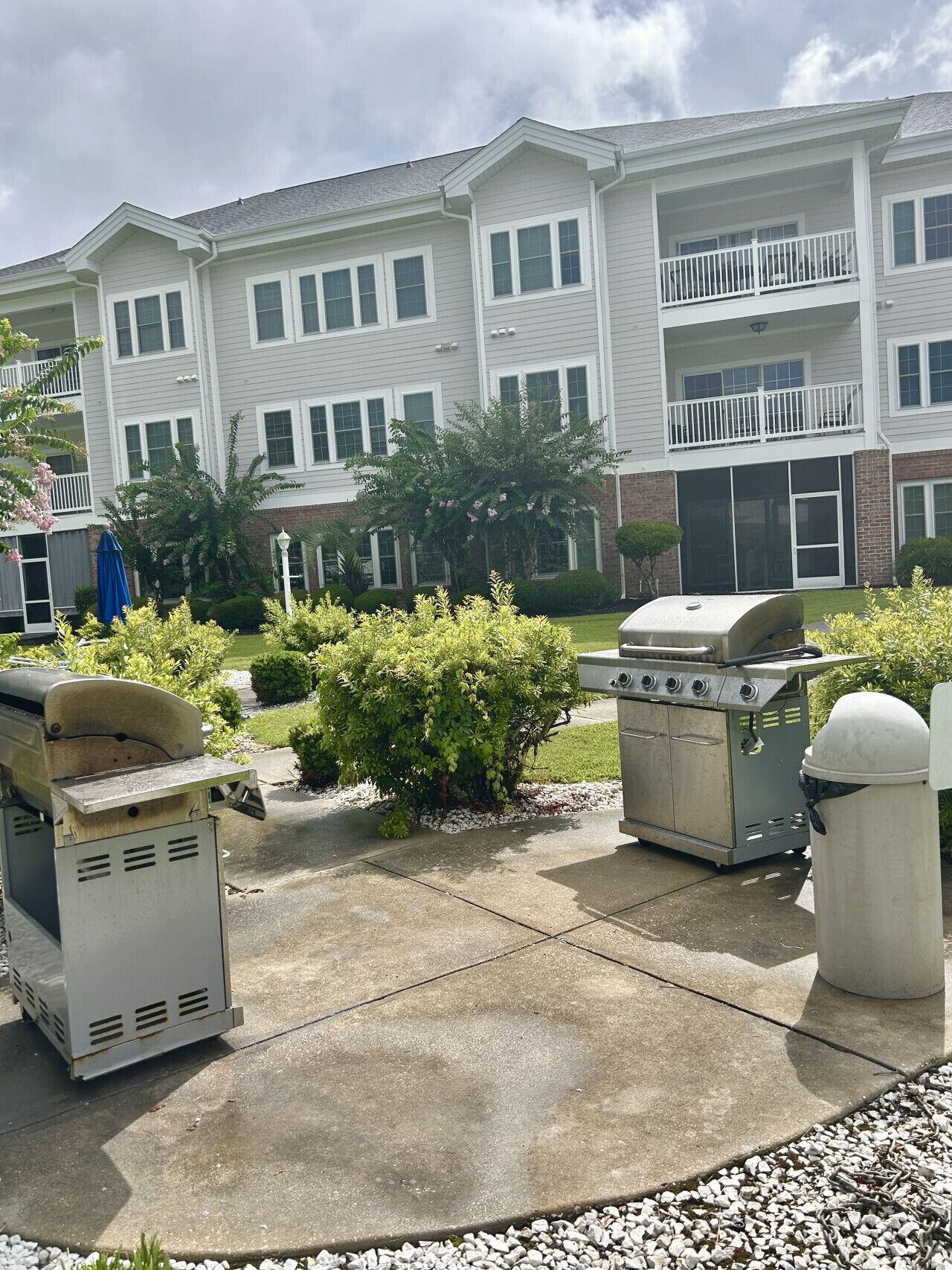 A residential building with a covered patio area featuring a barbecue grill and a portable generator.