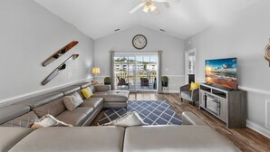 A spacious living room with a large sectional sofa, a flat-screen TV, and a ceiling fan. - Magnolia Pointe Magnolia Lake 4812-401 (Myrtle Beach)