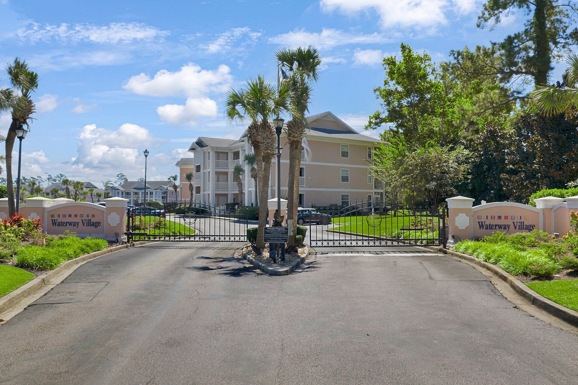 A gated entrance to a residential complex with a sign reading "Waterway Village."