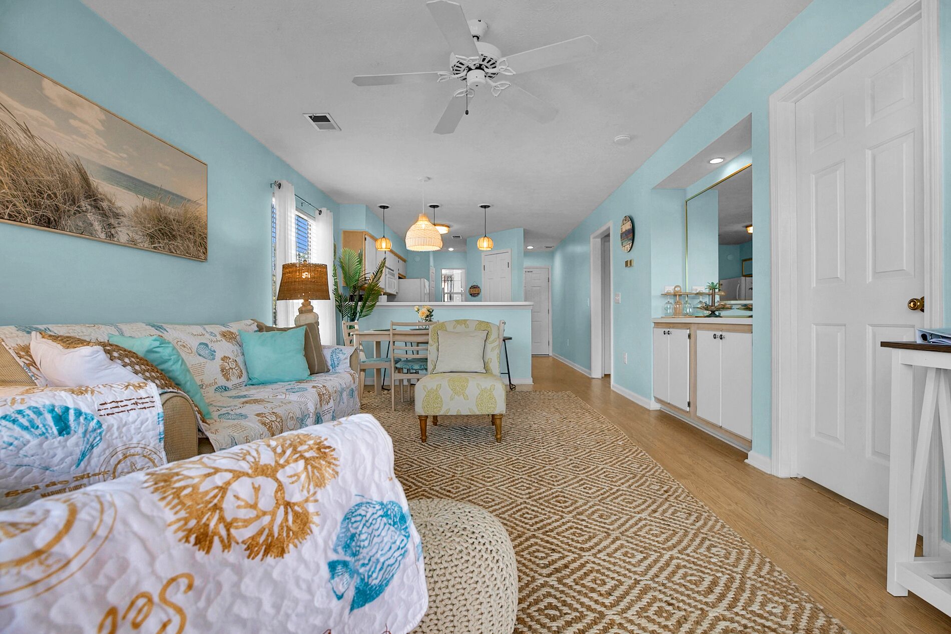 A spacious living room with a large sofa, a dining area, and a kitchen.