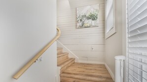 A wooden staircase with white walls and a radiator on the right. - Stockyards- 4min Pet Friendly 3BR Luxe Gem (Fort Worth)