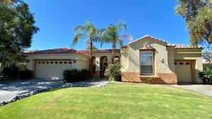 A residential house with a garage, a small attached structure, and a well-maintained lawn. - Villa Bella (Rancho Mirage)